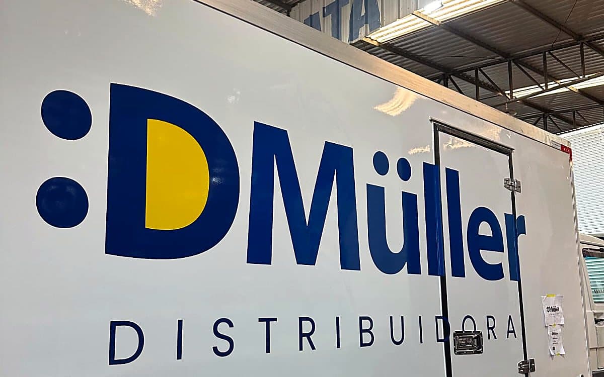 Detalhe da logomarca D Müller atravessando a porta lateral do baú