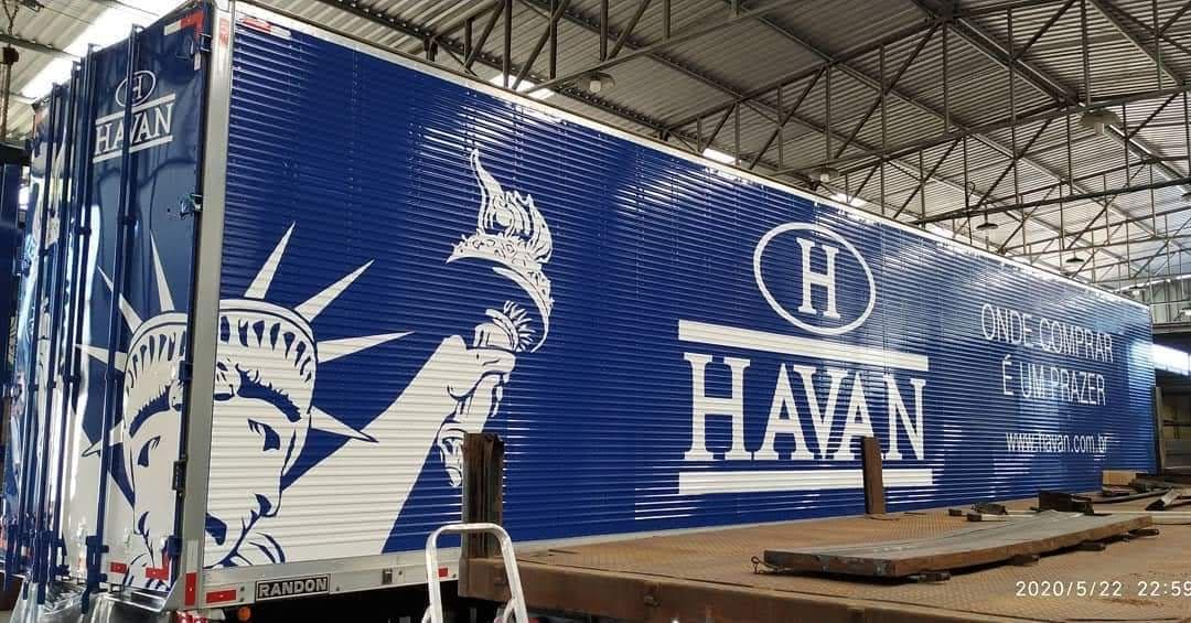 Semirreboque baú azul da Havan com a logomarca, o slogan Onde comprar é um prazer e a Estátua da Liberdade pintados em branco